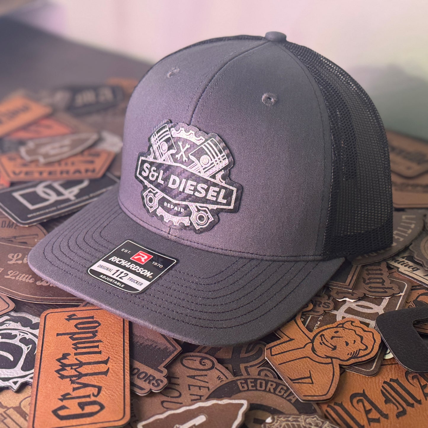 Gray cap with 'SL Diesel' logo on a background of various patches