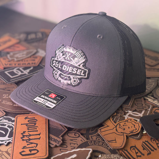 Gray cap with 'SL Diesel' logo on a background of various patches
